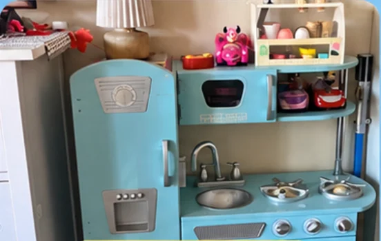 A blue wooden pretend-play kitchen with toy food